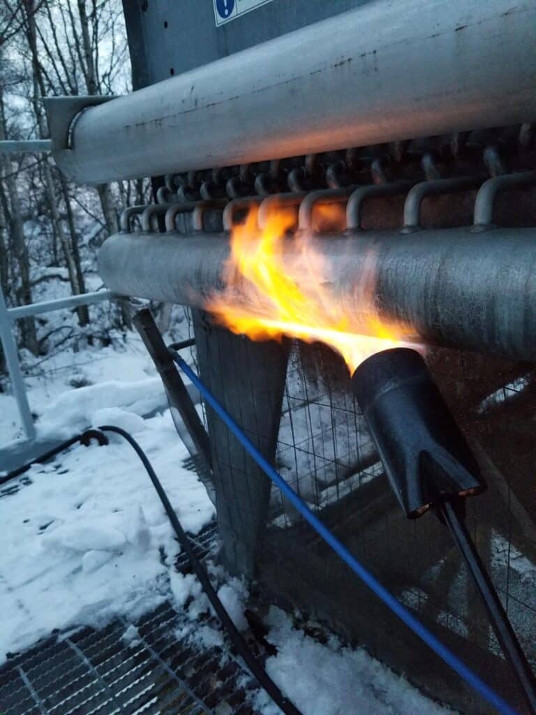 Torch heating a metal pipe